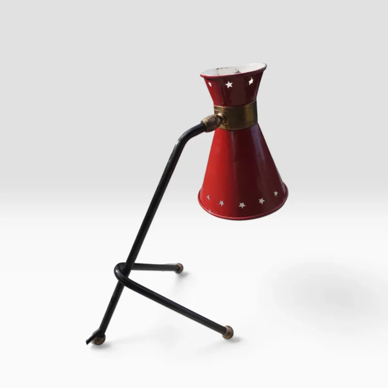 Side view of the red star-perforated shade and black tripod base, French table lamp attributed to René Mathieu for Maison Lunel