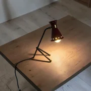 Lit red star-perforated shade table lamp attributed to René Mathieu for Maison Lunel, casting star-shaped light patterns