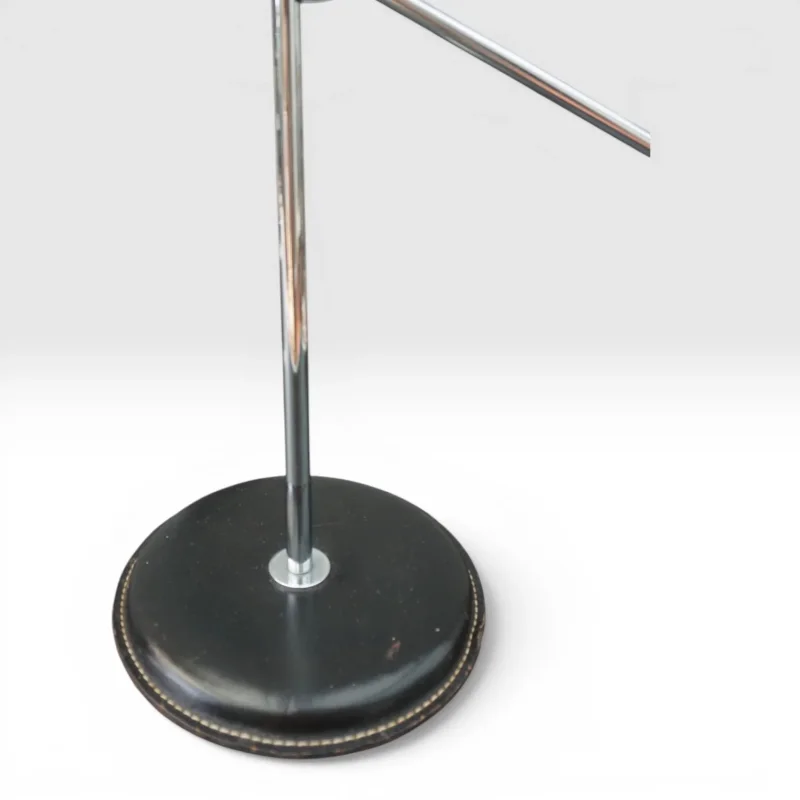 Close-up of the Ateljé Lyktan 781B leather-upholstered base with cream saddle stitching and chrome stem
