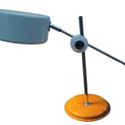 Side view of the Simris table lamp by Anders Pehrson with tilted shade, chrome arm and round leather base