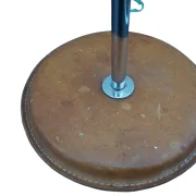 Close-up of the round tan leather base with white stitching and chrome stem of the Simris lamp