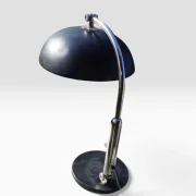 Side view of the black Hala Zeist model 144 desk lamp with dome shade, curved chrome arm and round base