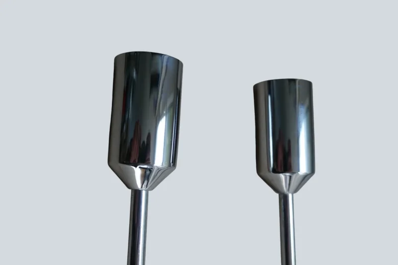 Two chrome finial end caps on rods of a pair of Cosack model 4166 wall sconces, shown side by side