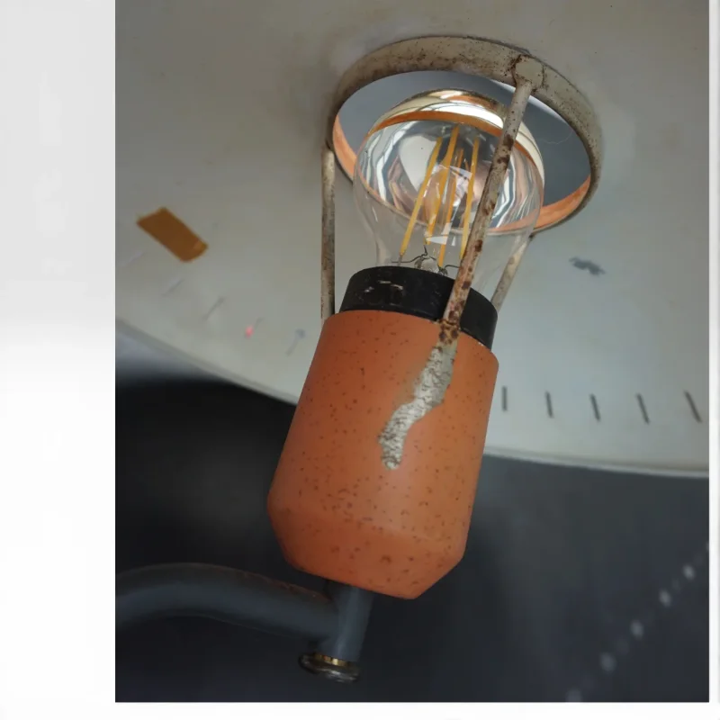 Close-up of Philips Junior socket housing showing paint loss and age wear on orange lacquer, 1950s